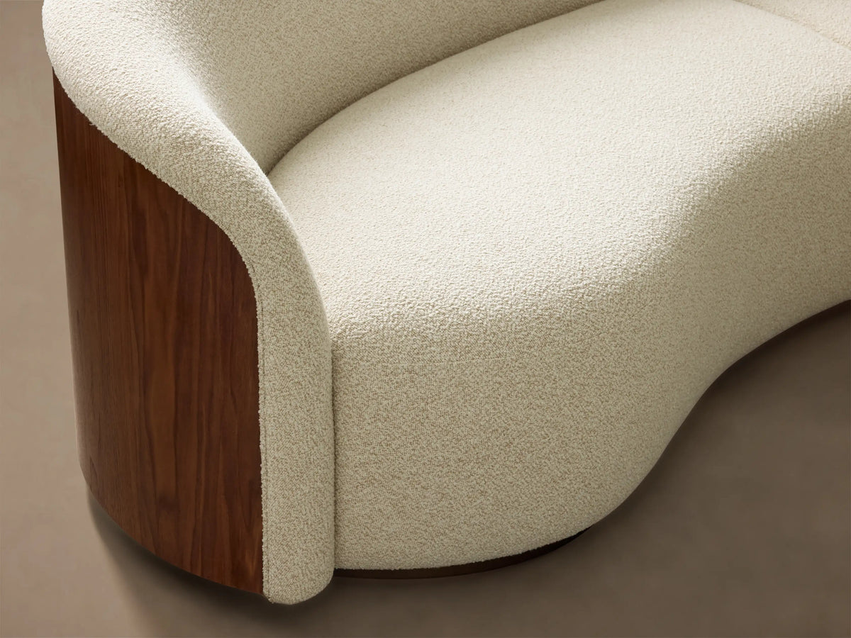 Front view of the curved Caden Three-Piece Sectional, featuring off-white upholstery and walnut wood veneer panels.