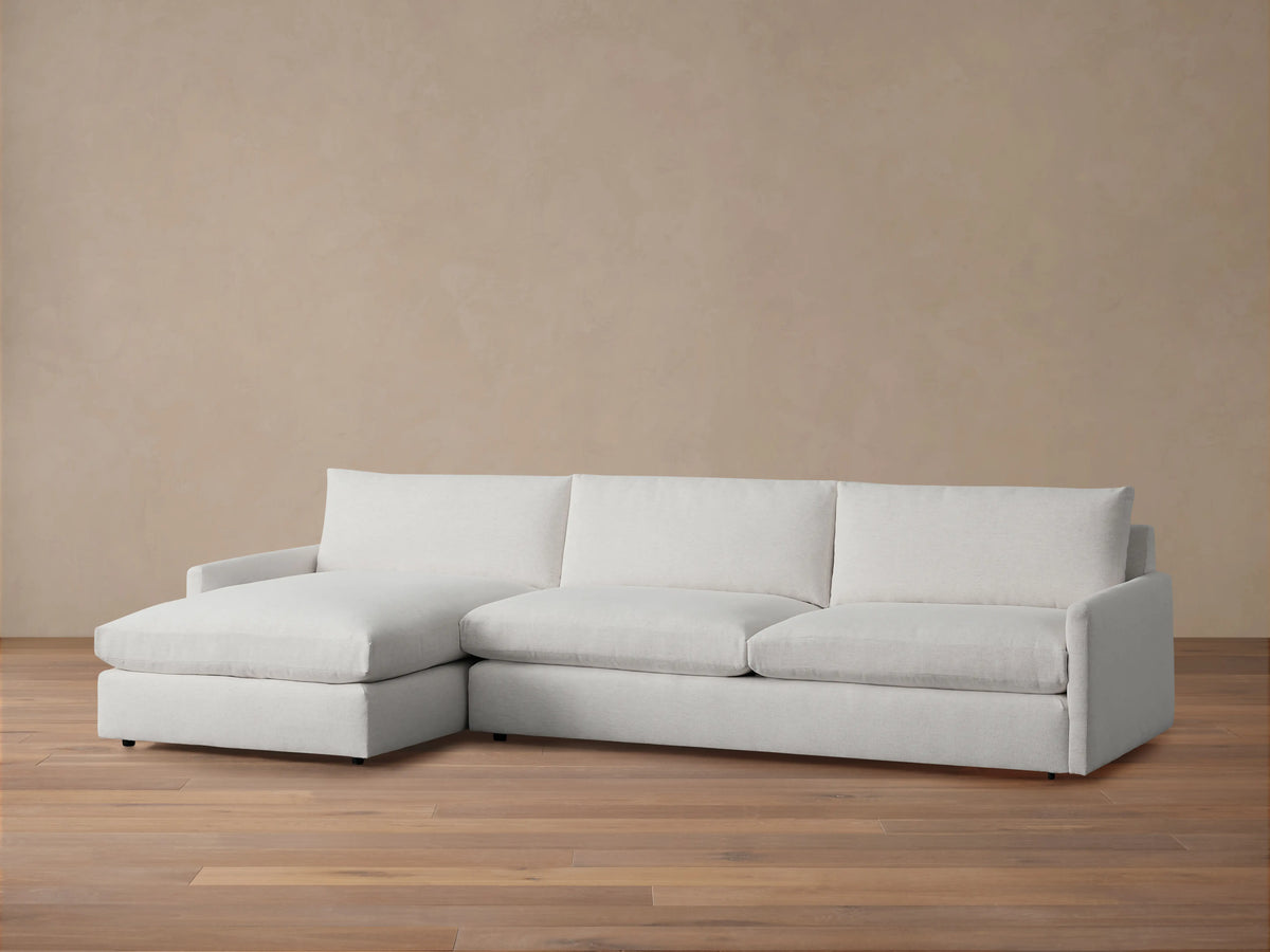 Kipton Two-Piece Chaise Sectional in light beige fabric, featuring left-facing chaise. Set on wooden floor with neutral backdrop.