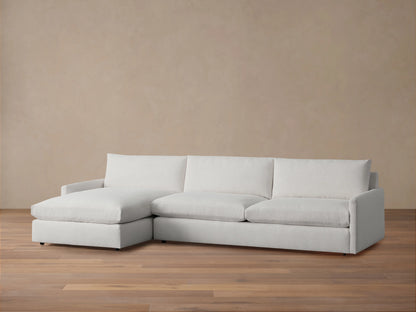 Kipton Two-Piece Chaise Sectional in light beige fabric, featuring left-facing chaise. Set on wooden floor with neutral backdrop.