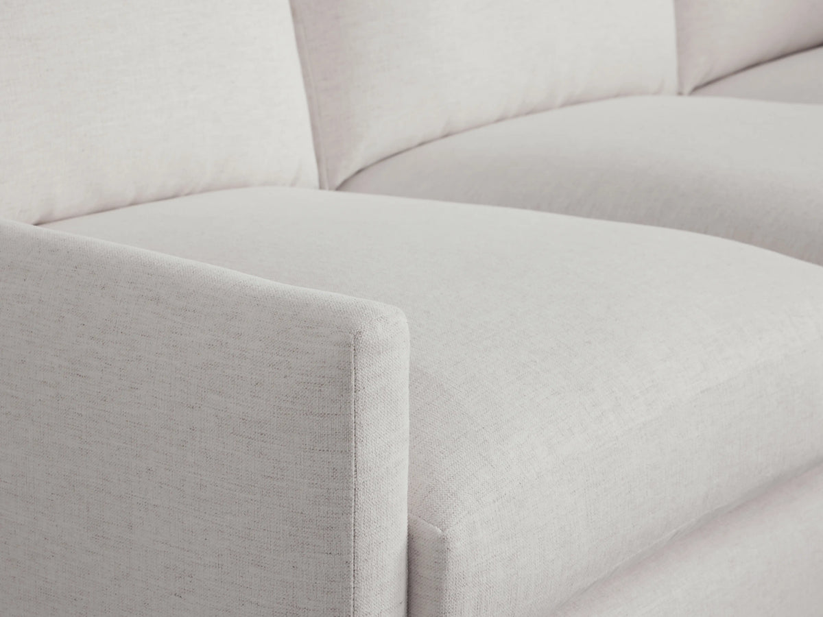 Kipton Two-Piece Chaise Sectional in light gray fabric, featuring a clean edge armrest and plush, cushioned seating.