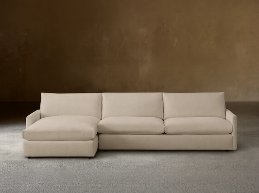 Kipton Two-Piece Chaise Sectional in a neutral beige fabric, featuring a left-side chaise and right-side loveseat on a wooden floor.