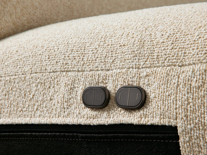Brennan Motion Sofa, close-up of light beige textured fabric, plush seat/back cushions, and armrest. Footrest partially visible.