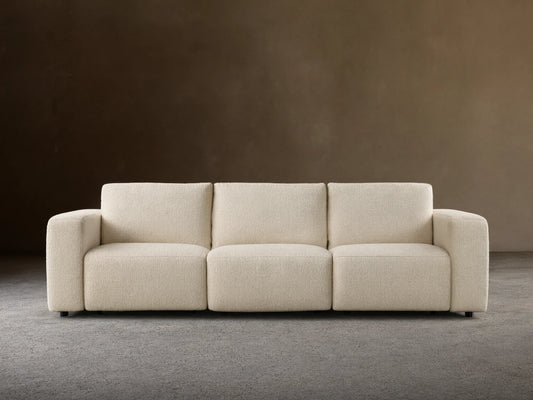 Brennan Three-Piece Motion Sofa, light cream textured fabric, modern design with blocky arms & cushions, on wood floor.