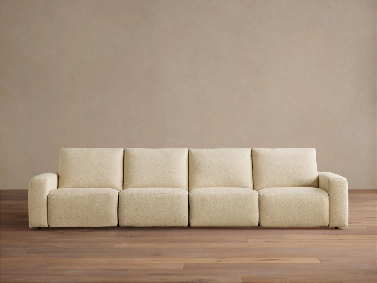 Brennan Four-Piece Motion Sectional sofa, light beige textured fabric, front view on a wooden floor.