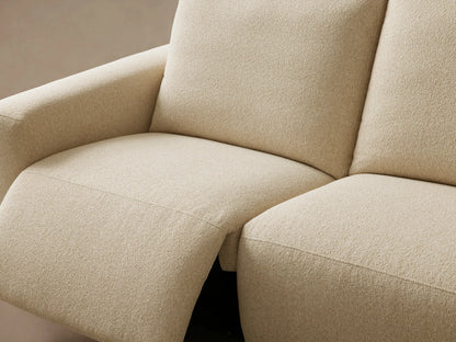 Brennan Four-Piece Motion Sectional in cream-colored textured fabric, viewed straight on against a light tan wall.