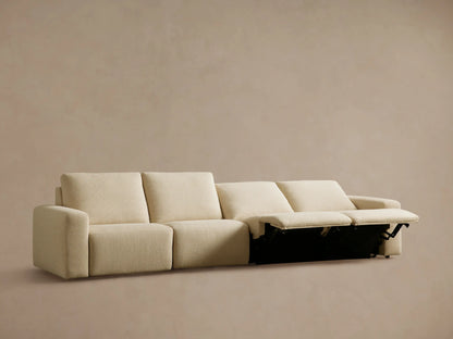 Brennan Four-Piece Motion Sectional in light beige, with the left recliner's footrest partially extended.