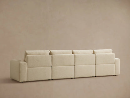 Light beige Brennan Four-Piece Motion Sectional sofa, right section reclined with footrest extended, against a plain wall.
