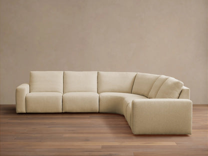 Brennan Five-Piece Motion Corner Sectional: light beige L-shaped sofa with curved corner against a neutral wall, wood floor.