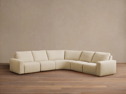 Brennan Five-Piece Motion Corner Sectional: light beige L-shaped sofa with curved corner against a neutral wall, wood floor.