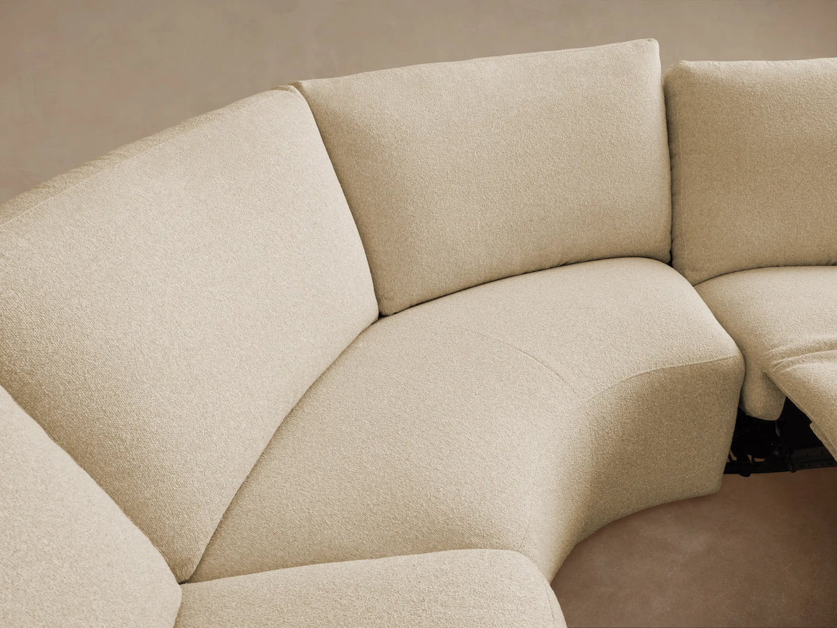 Cream Brennan Five-Piece Motion Corner Sectional with block arms and soft cushions on a wood floor against a plain wall.