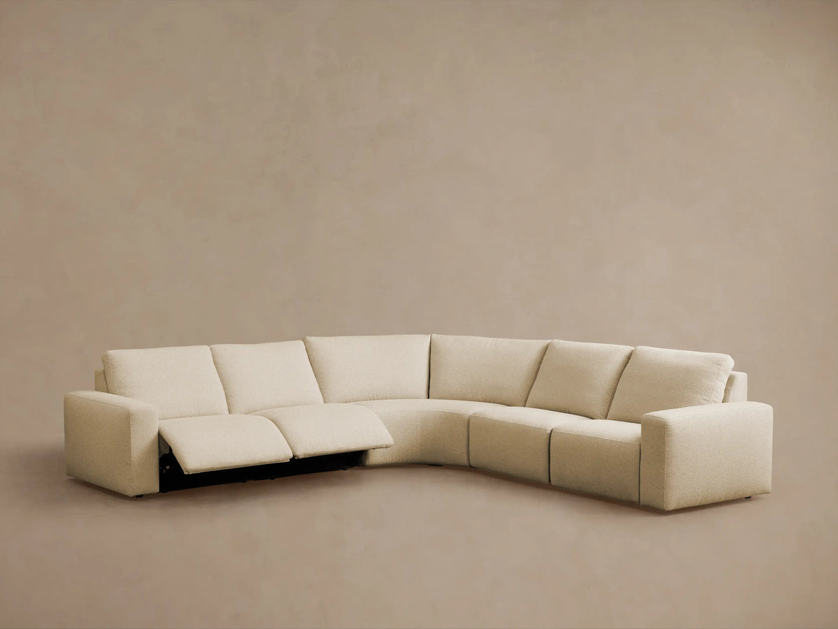 Close-up of Brennan motion sectional's textured beige fabric with two dark oval control buttons embedded in the side cushion.