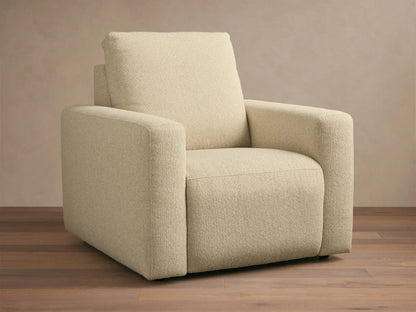 Brennan Motion Recliner in light beige textured fabric, an upright armchair with wide arms, on a wooden floor.