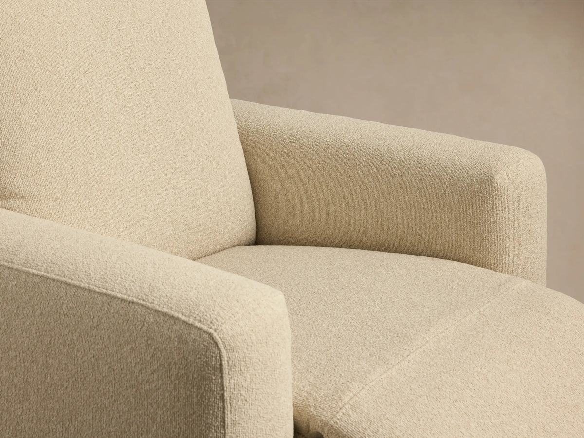 Brennan Motion Recliner, cream textured fabric, full front view. High back, wide arms, on wood floor against beige wall.
