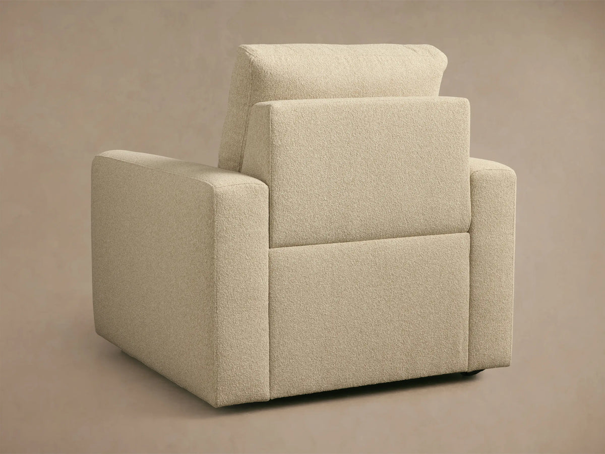 Brennan Motion Recliner in light beige textured fabric, showing a close-up of the arm, seat, and back cushion.