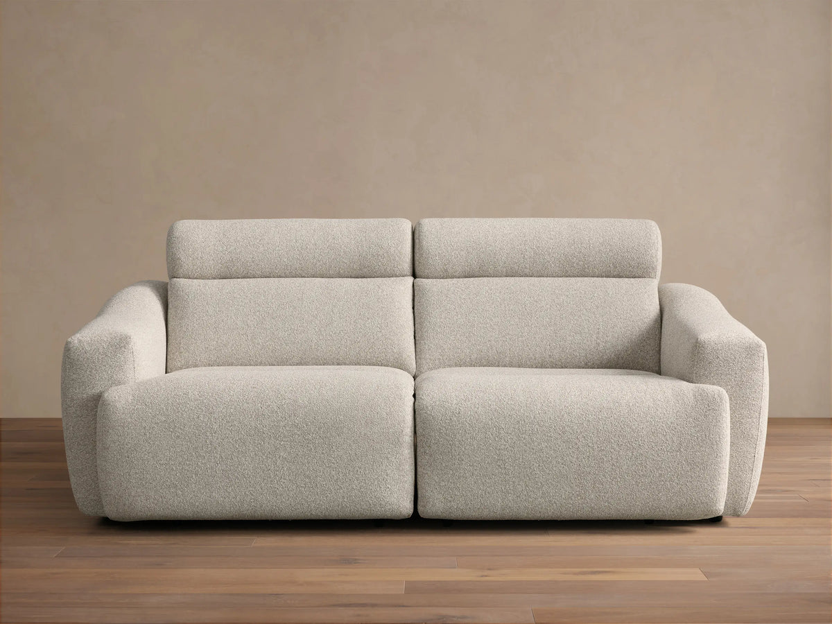 Front view of the Light beige Fia Two-Piece Motion Sofa, showing its textured bouclv© fabric and separate headrest sections.