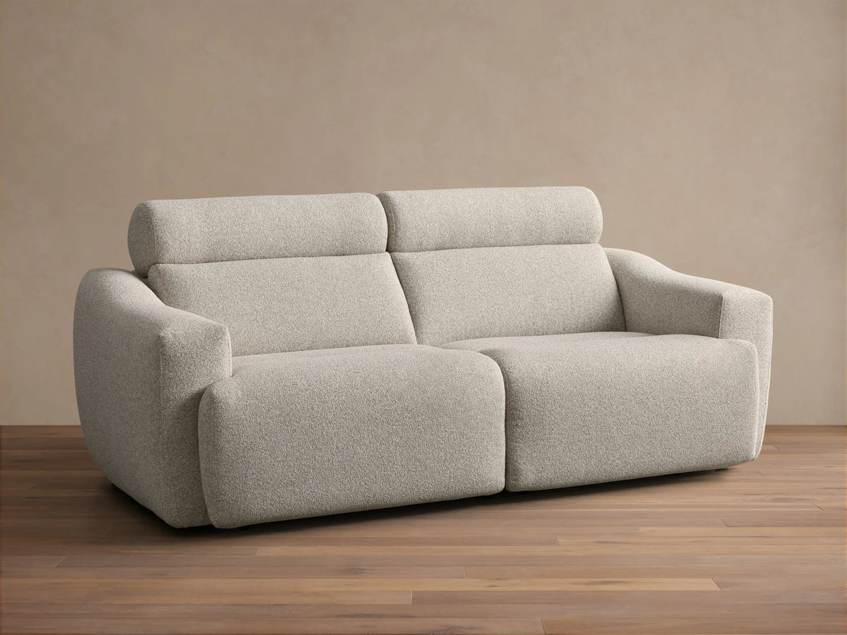 Front view of the Light beige Fia Two-Piece Motion Sofa, showing its textured bouclv© fabric and separate headrest sections.