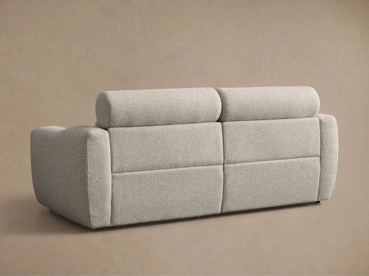 Close-up of the light grey textured Fia Two-Piece Motion Sofa with the right footrest extended.