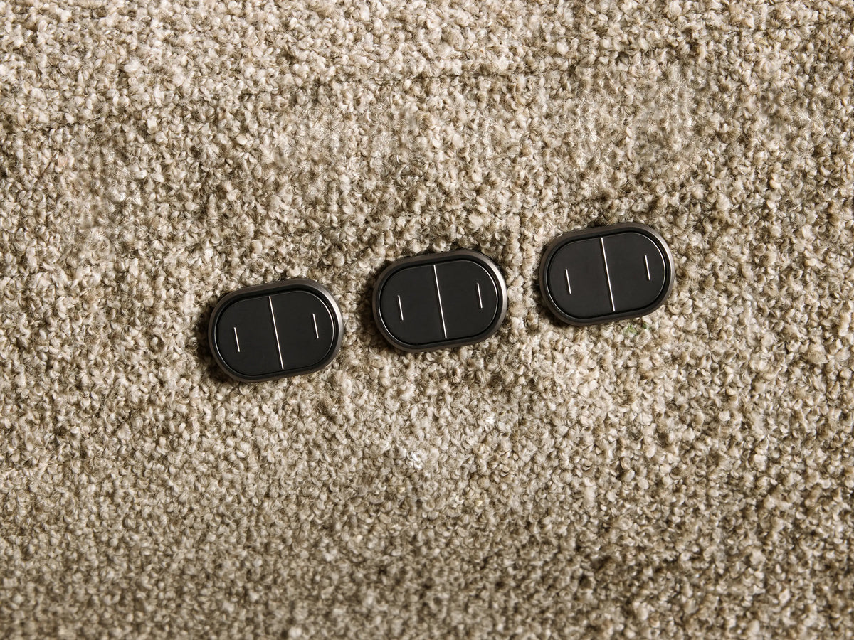 Close-up of the light brown textured fabric of the Perry Two-Piece Motion Sofa with an extended footrest and tufted cushions.