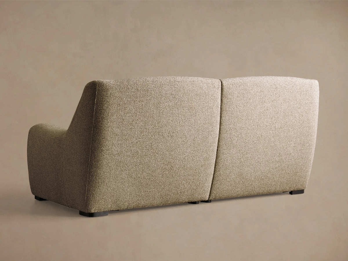 Close-up of three black oval motion control buttons embedded in the beige textured upholstery of the Perry Two-Piece Motion Sofa.