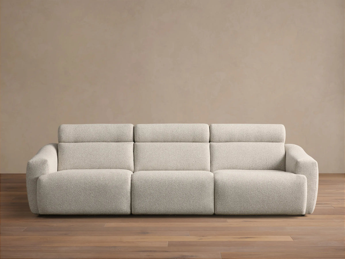 Front view of the light gray Fia Three-Piece Motion Sofa with integrated headrests and textured upholstery.