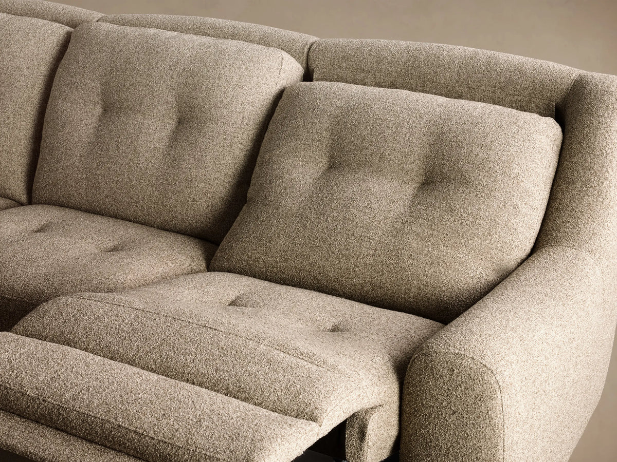 Front 3/4 view of the oatmeal textured Perry Three-Piece Motion Sofa with button tufting on the back cushions and rounded arms.