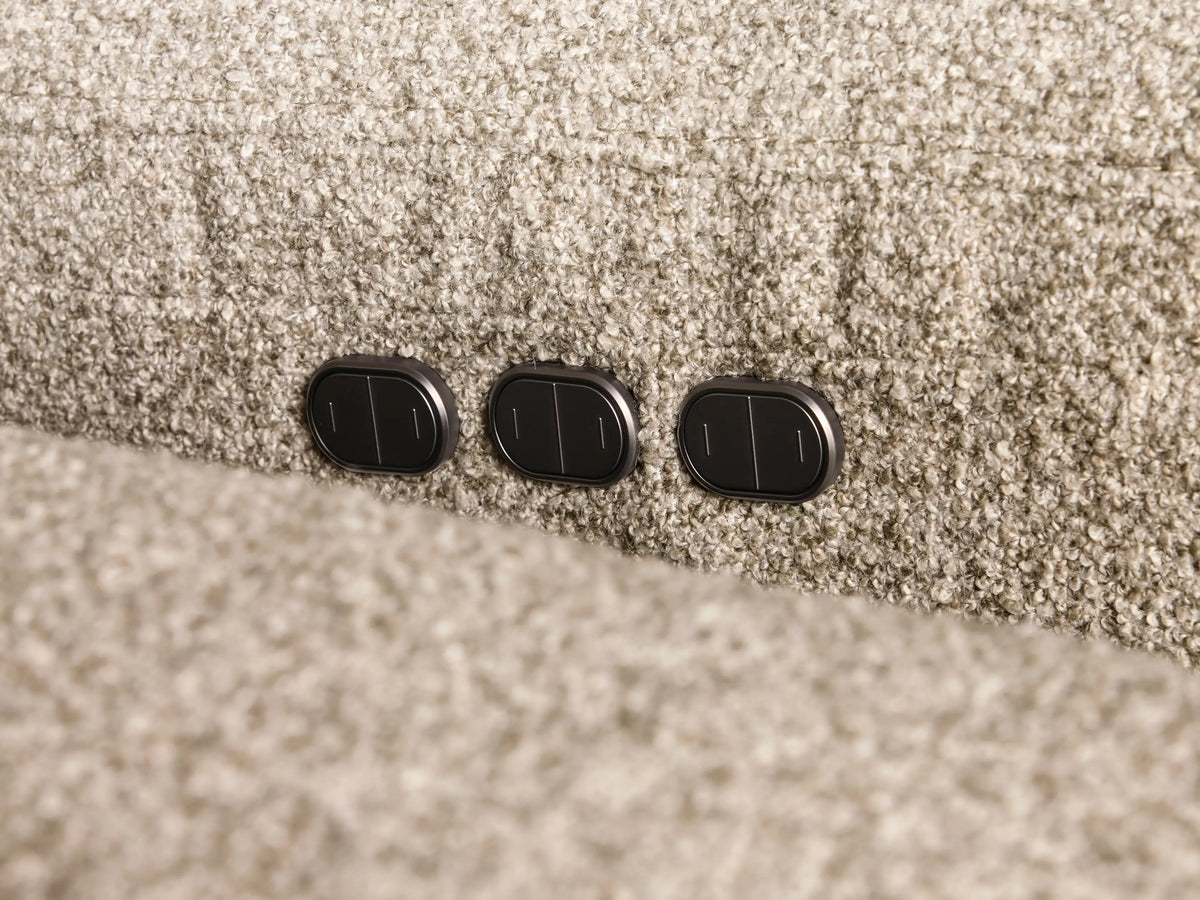 Close-up of the light brown textured fabric of the Perry Three-Piece Motion Sofa with tufted cushions and an extended footrest.