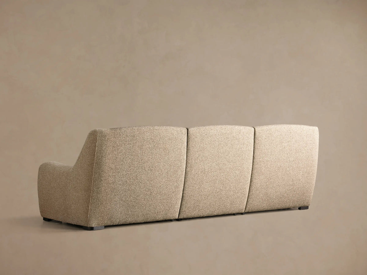 Close-up of three black oval motion control buttons embedded in the light grey textured fabric of the Perry Three-Piece Motion Sofa.