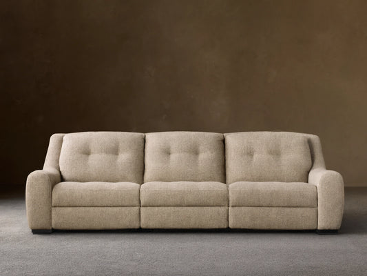 Front view of the light beige textured Perry Three-Piece Motion Sofa, featuring three seats with button-tufted back cushions.