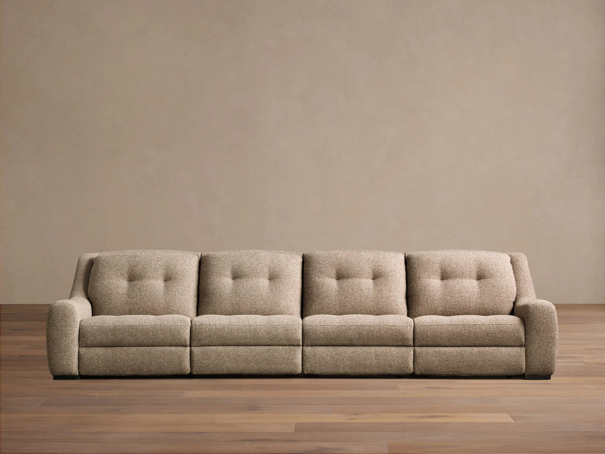 Front view of the beige tweed Perry Four-Piece Motion Sectional with four seats, tufted backs, and wide arms.