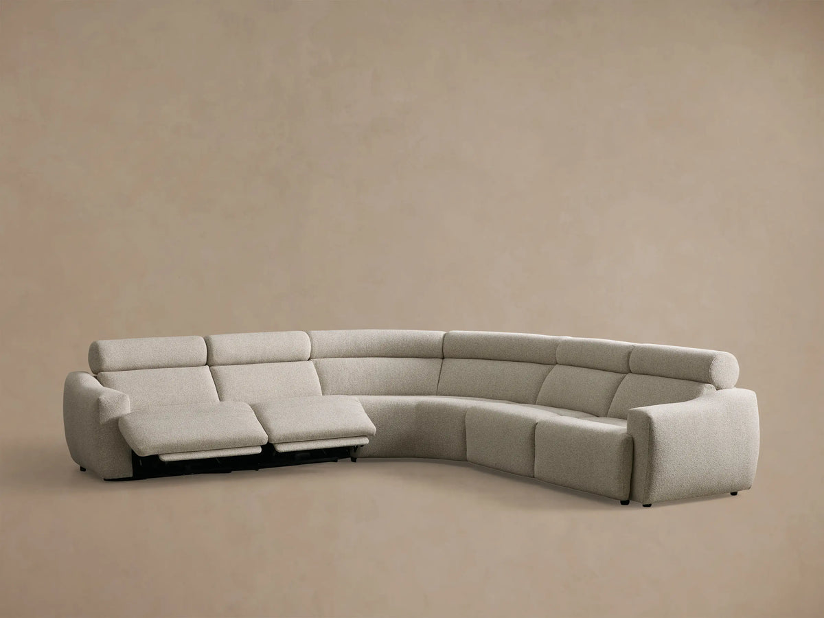 Rear view of the light beige Fia Five-Piece Motion Corner Sectional, showing its curved back with segmented cushions.