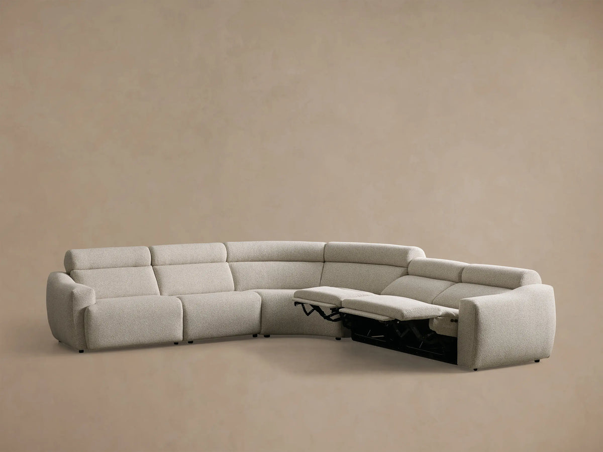 Front view of the light beige Fia Five-Piece Motion Corner Sectional with two left sections reclined and footrests extended.