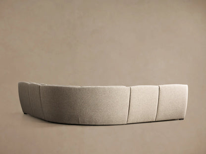 Front-side view of a light greige textured Perry Five-Piece Motion Corner Sectional with tufted cushions, one section reclined.