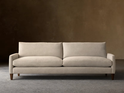 Front view of a light beige Kipton Slim Arm Elevated Sofa with slim arms and dark mocha finish legs.