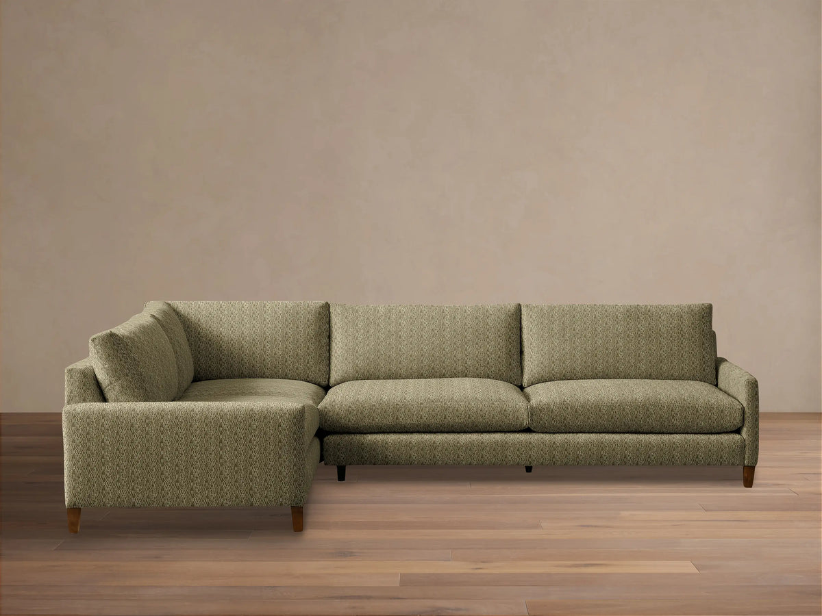 Front view of the L-shaped Kipton Slim Arm Elevated Two-Piece Sectional, upholstered in olive green patterned fabric, with slim arms and mocha feet.