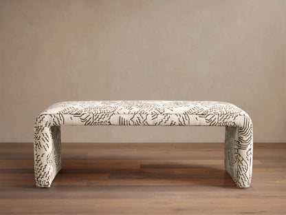 Ryan Bench, U-shaped, fully upholstered in cream fabric with dark brown abstract squiggle pattern, on a wood floor.