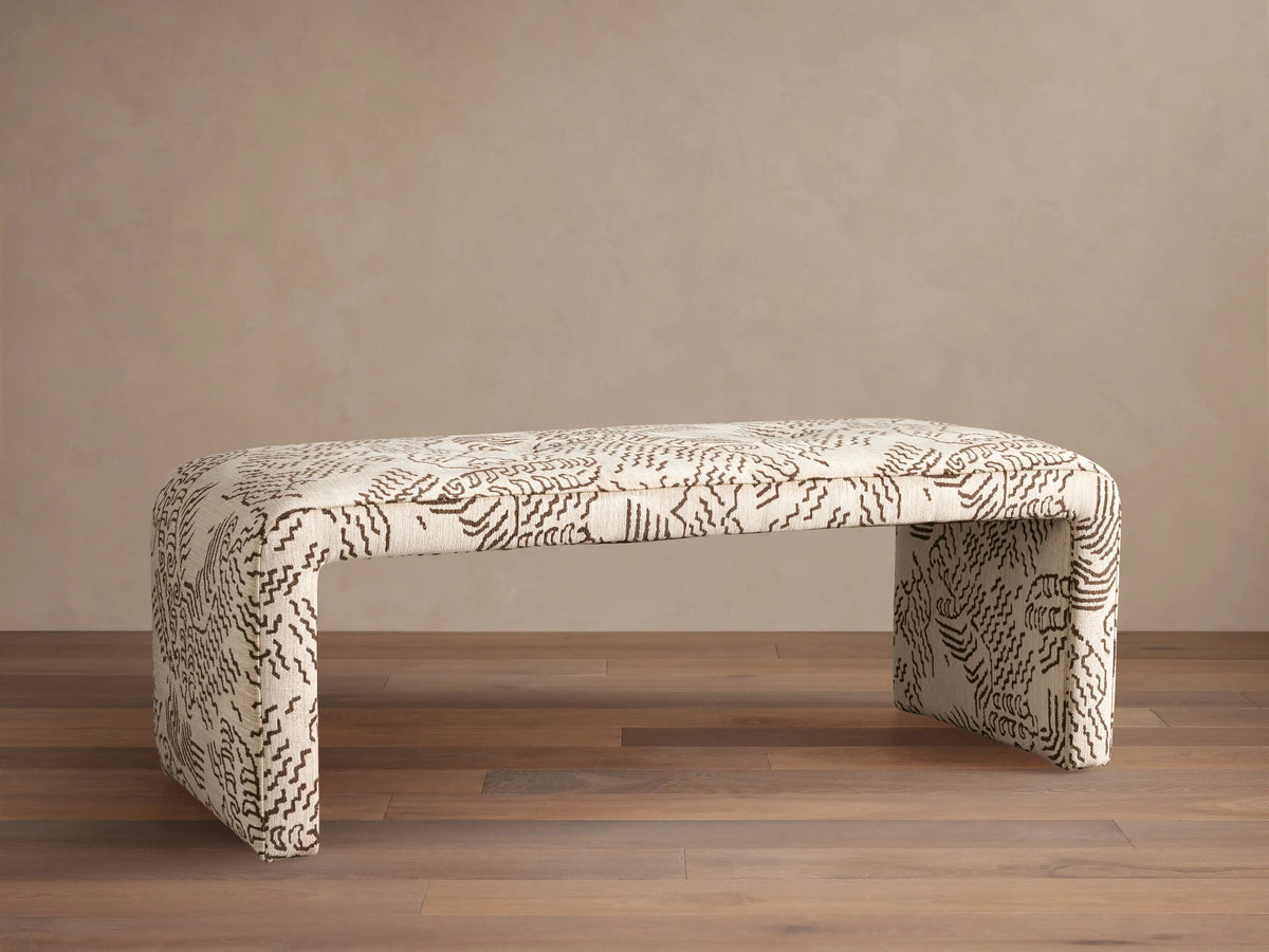 Ryan Bench, U-shaped, fully upholstered in cream fabric with dark brown abstract squiggle pattern, on a wood floor.