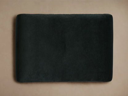 Ryan Ottoman in Banks Midnight, dark upholstered fabric, rectangular shape with a single button tuft on top, positioned on a neutral background.