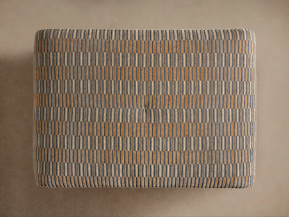 Ryan Ottoman with a textured, striped fabric in shades of gray and tan. It has a rectangular shape with a cushioned top and subtle tufting.