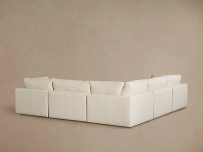 Close-up of the Beale Five-Piece Corner Sectional. Light beige, textured boucle fabric covers plush armrest, seat, and back cushions.