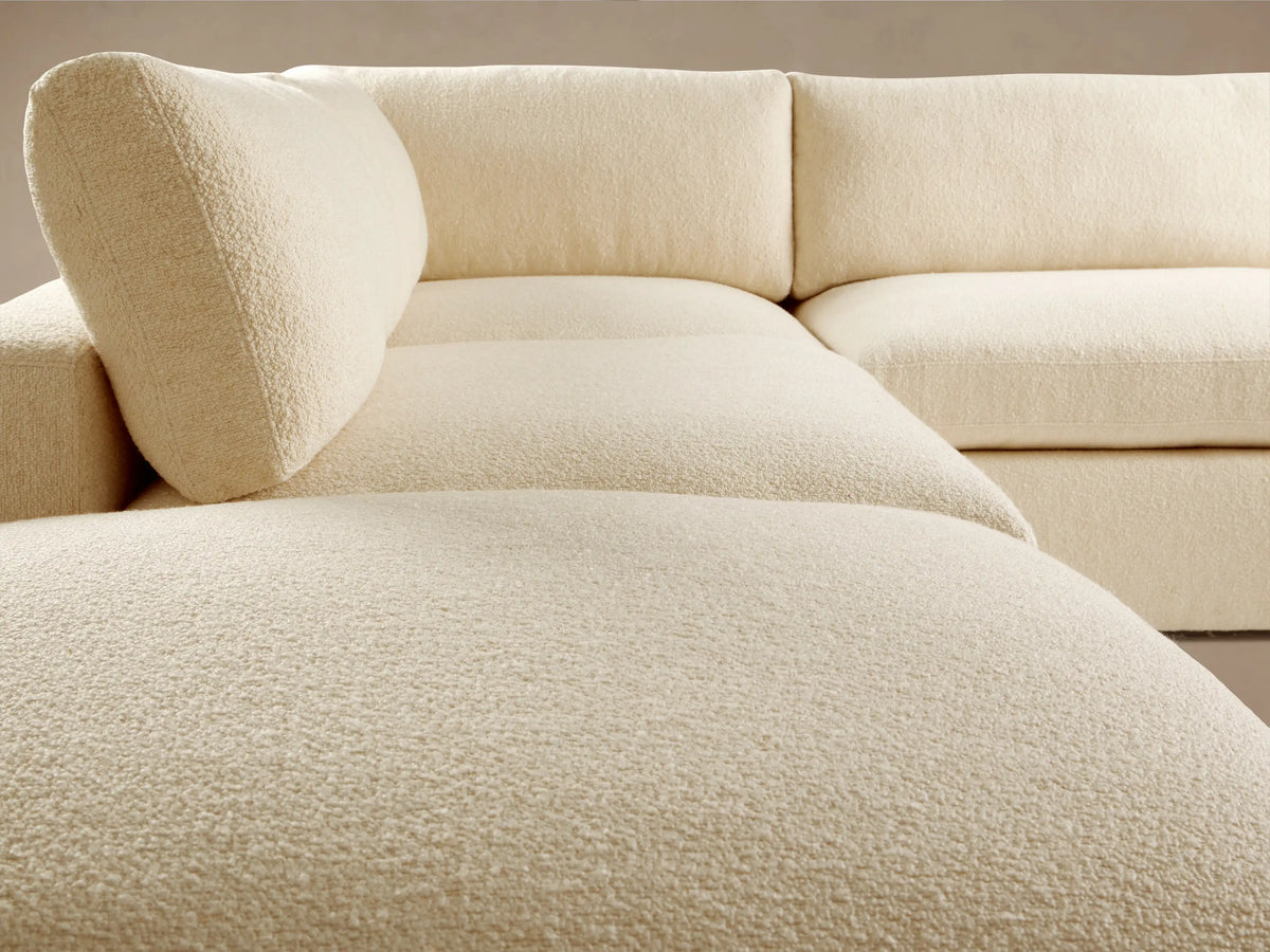 Beale Five Piece Sectional sofa, L-shaped, soft cream textured fabric, with a left chaise, on a light wood floor.