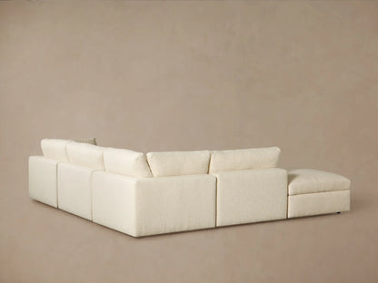 Close-up of a cream-colored Beale Five Piece Sectional sofa, featuring plush, textured boucle fabric on soft seat and back cushions.