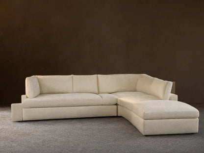 Beale Five Piece Sectional, cream L-shaped modular couch with chaise on left, against a light wall & wood floor.