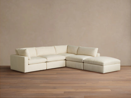Beale Five Piece Sectional: L-shaped, off-white textured fabric sofa with plush cushions, on a light wood floor.