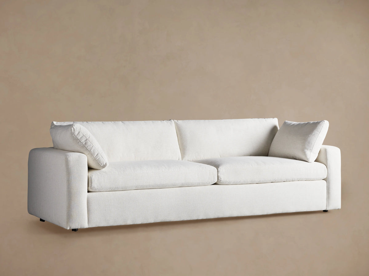 Angled close-up of the Beale Sofa, showcasing its plush, textured off-white fabric, deep seat cushions, and soft back.