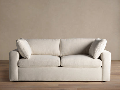 Close-up of the cream Beale Sofa, highlighting the textured fabric on the armrest, a plush back cushion, and a seat cushion.