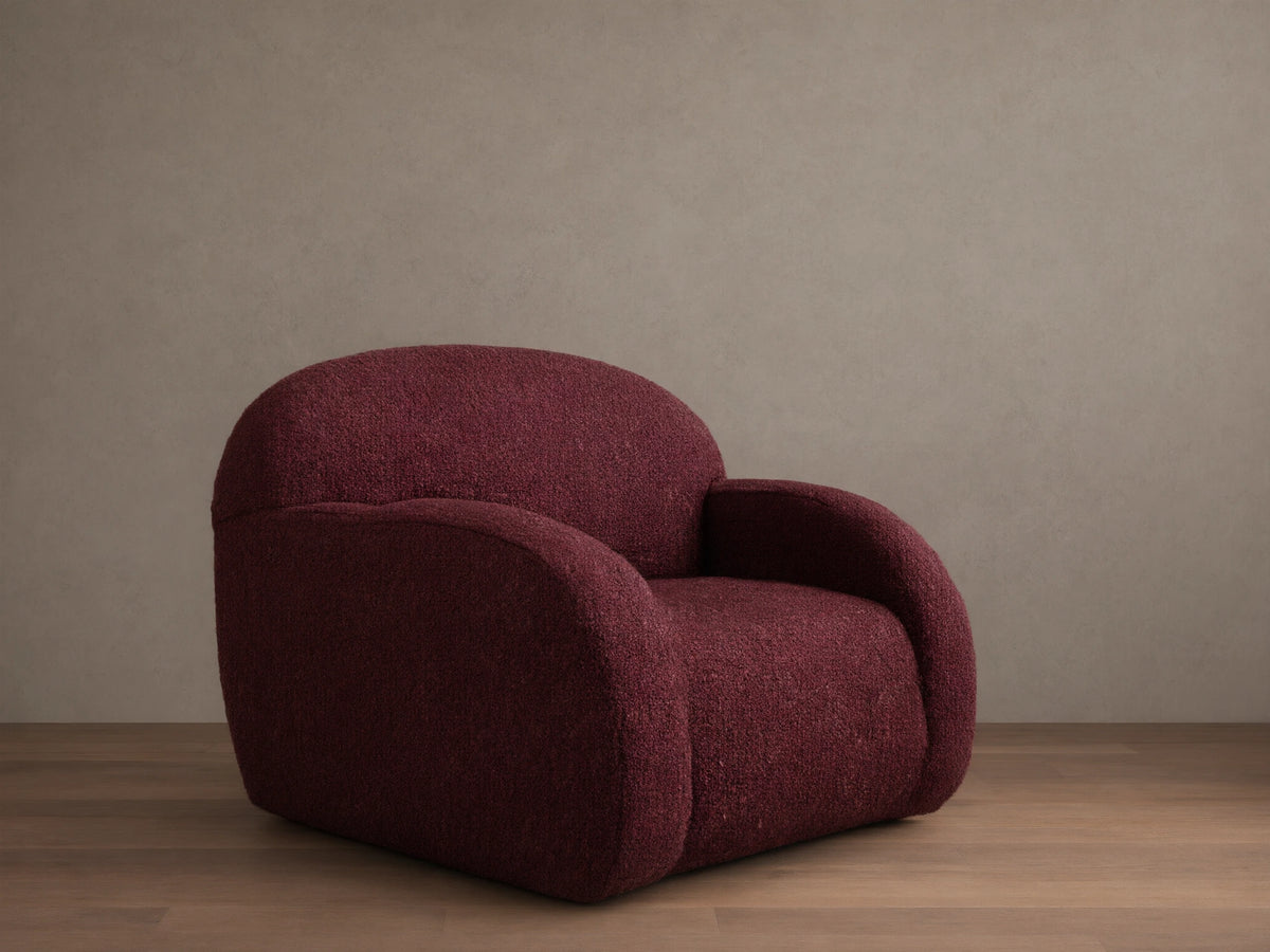Front view of the burgundy Algiers Swivel Chair, upholstered in a textured fabric with a rounded, modern design.