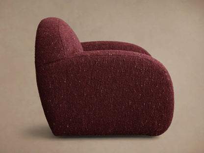 Side profile of the deep red Algiers Swivel Chair, upholstered in a textured fabric with a rounded shape.