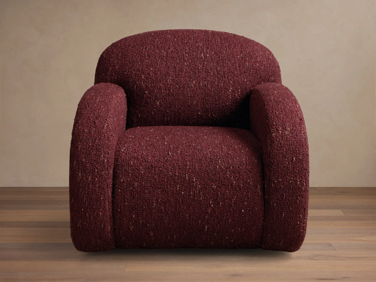 Front view of the burgundy Algiers Swivel Chair, featuring a plush, rounded silhouette and curved arms in textured fabric.