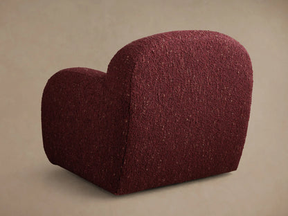 Angled rear view of the deep red Algiers Swivel Chair with a rounded, armless form and flecked fabric.