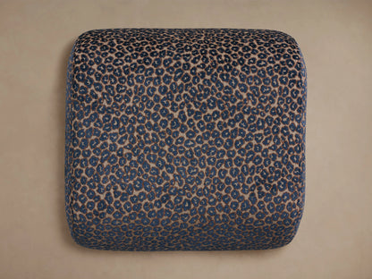 Close-up of Fresno Ottoman upholstered in a blue and beige leopard print fabric, showing its rounded top and side.